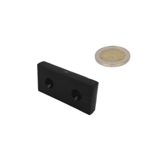 Blokmagneet van 50.8x25.4x8 mm met verzonken gaten en een kunststof omhulsel, geplaatst naast een 2-euromunt op een witte achtergrond. De munt dient als maatvergelijking om de afmetingen van de magneet te illustreren.